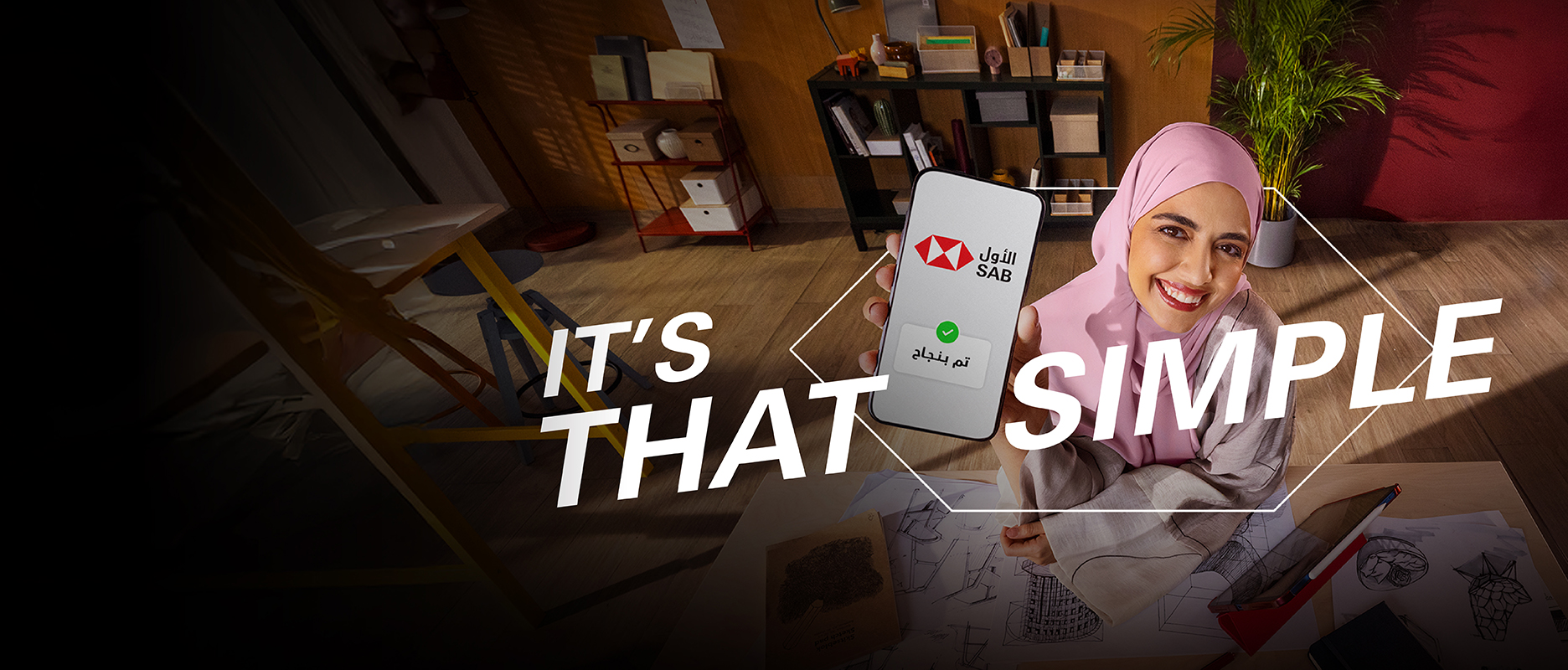 a designer saudi woman in her office showing her phone with words baseetah written in Arabic