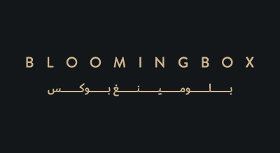 This is a logo for "BLOOMINGBOX", a brand name that likely represents a business related to gifting, flowers, or luxury packaging. The design is minimalistic, with the brand name written in both English and Arabic (بلومينغ بوكس),