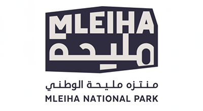 The image shows a logo with the name "Mleiha National Park  " written in orange letters.The background is white