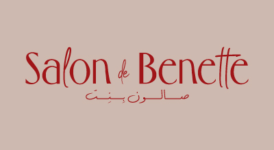 تظهر الشعار" Salon DeBenette" باللون الاحمر مع الخلفيه باللون الوردي